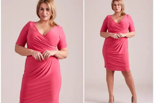 Eleganckie sukienki dla puszystych: modelka w różowej, kopertowej kreacji z drapowanym dołem.